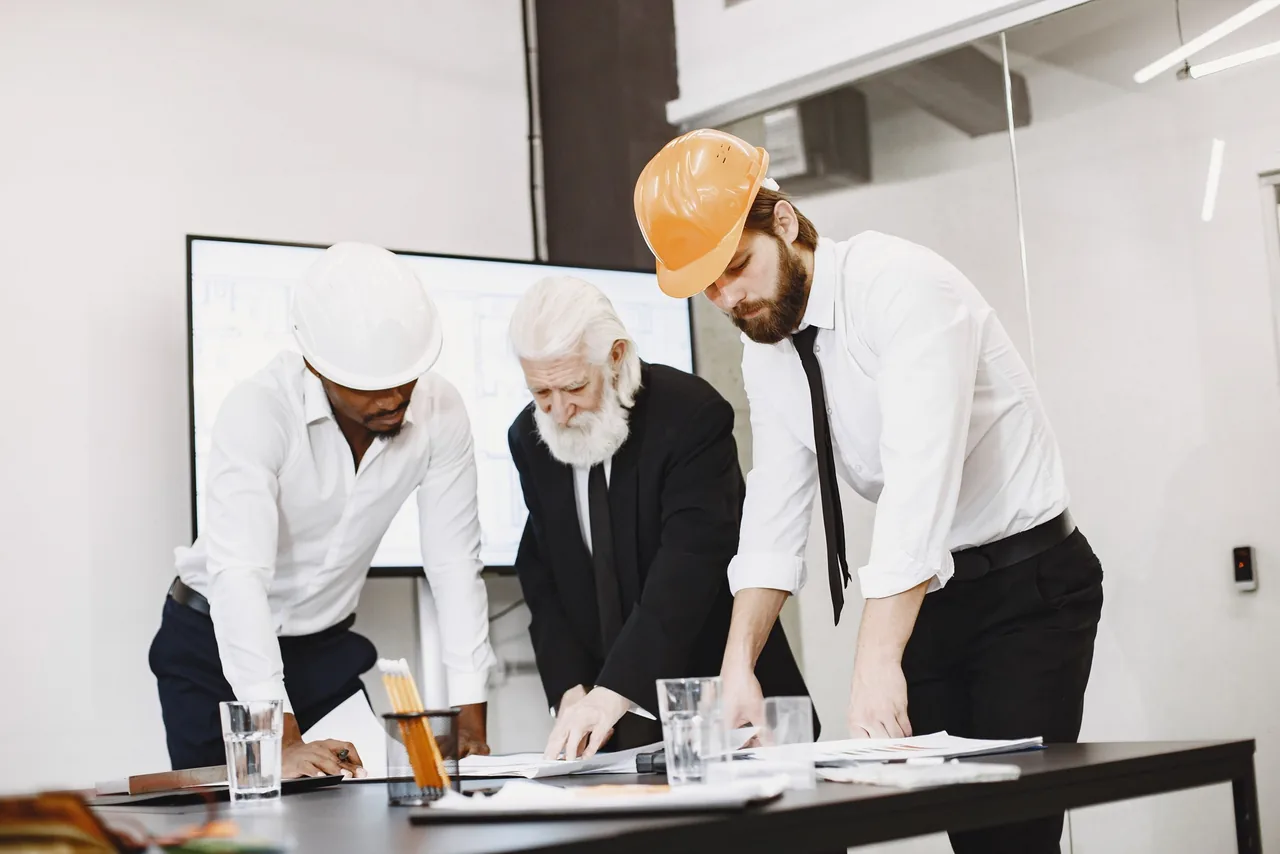 Profesionales revisando planos para la evaluación de un proyecto
